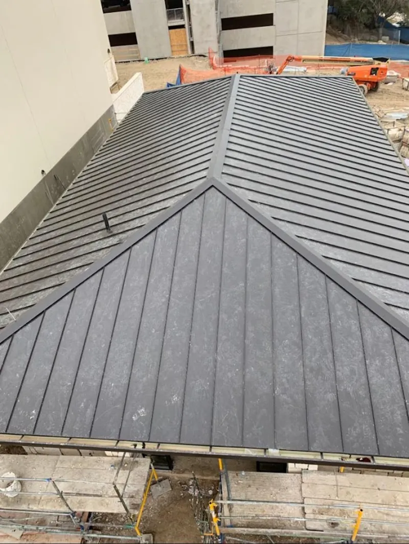 Commercial metal roof construction with crane equipment in Wentzville
